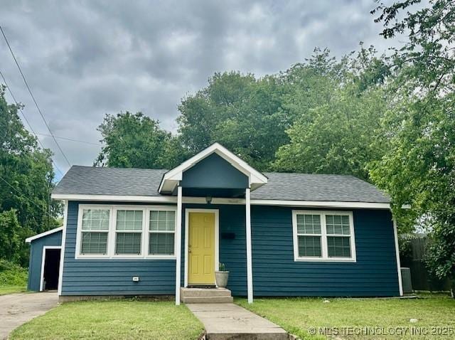 16 Q St SW, Ardmore, OK 73401 - view of front of home with a front lawn, a shingled roof, and entry steps