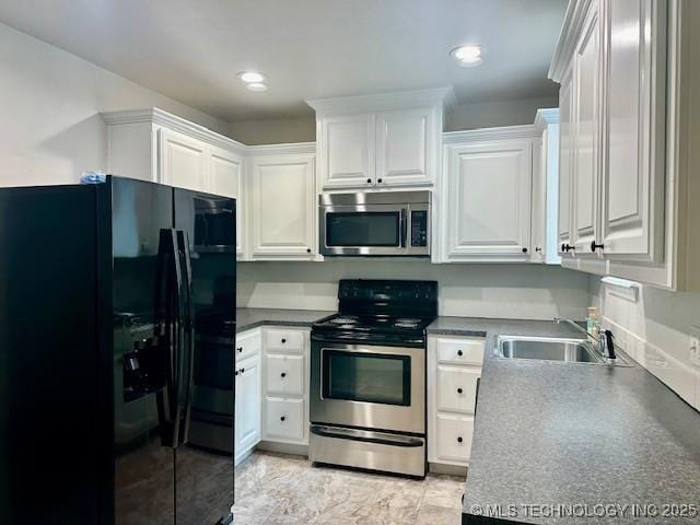 16 Q St SW, Ardmore, OK 73401 - kitchen featuring appliances with stainless steel finishes, a sink, white cabinetry, recessed lighting, and dark countertops
