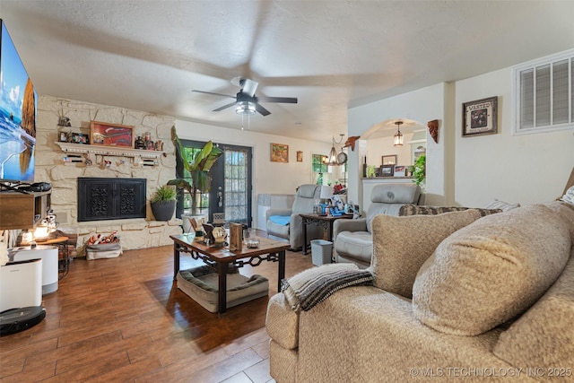 62820 E 312th Rd, Grove, OK 74344 - living room with ceiling fan, wood-type flooring, arched walkways, a fireplace, and a chandelier