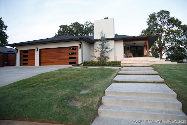 2233 E 32nd St, Tulsa, OK 74105 - contemporary house featuring a chimney, a garage, driveway, and a front lawn