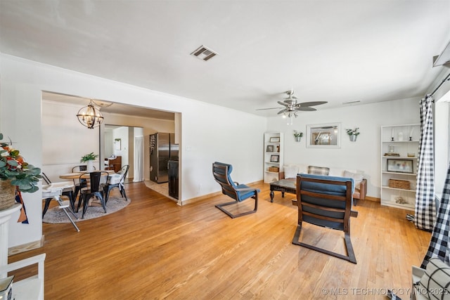 303 SE 3rd St, Pryor, OK 74361 - living room featuring light wood-type flooring, ceiling fan, a chandelier, and baseboards