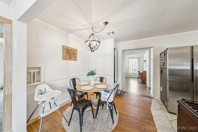 303 SE 3rd St, Pryor, OK 74361 - dining room with ornamental molding, a chandelier, and light wood finished floors