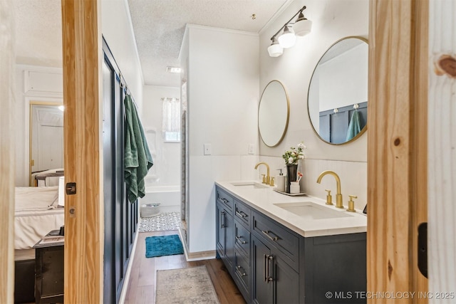 303 SE 3rd St, Pryor, OK 74361 - full bath with double vanity, wood finished floors, and a textured ceiling