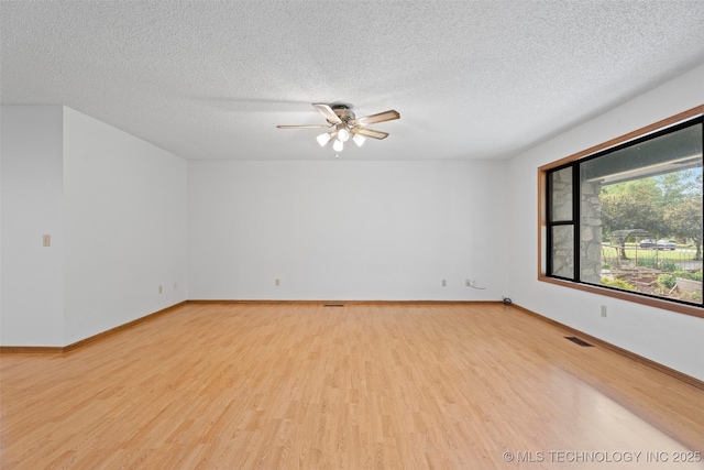 1558 E N Ridge Dr, Vinita, OK 74301 - spare room with light wood-style floors, a textured ceiling, ceiling fan, and baseboards