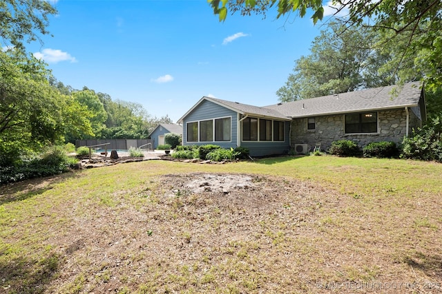 1558 E N Ridge Dr, Vinita, OK 74301 - back of property with stone siding, a sunroom, and roof with shingles