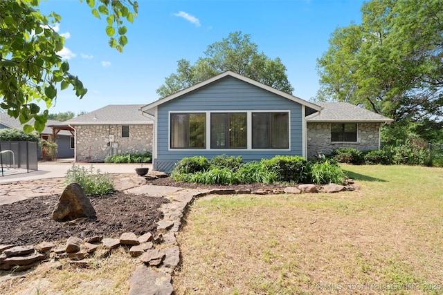 1558 E N Ridge Dr, Vinita, OK 74301 - view of front of property featuring stone siding, a front lawn, a patio area, and a shingled roof