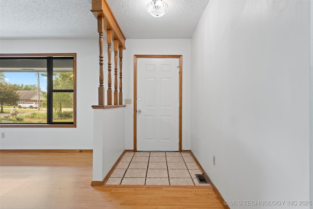 1558 E N Ridge Dr, Vinita, OK 74301 - entryway featuring a textured ceiling, light wood finished floors, and baseboards