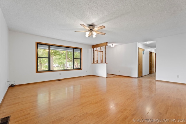 1558 E N Ridge Dr, Vinita, OK 74301 - spare room with ceiling fan, light wood-style flooring, a textured ceiling, and baseboards