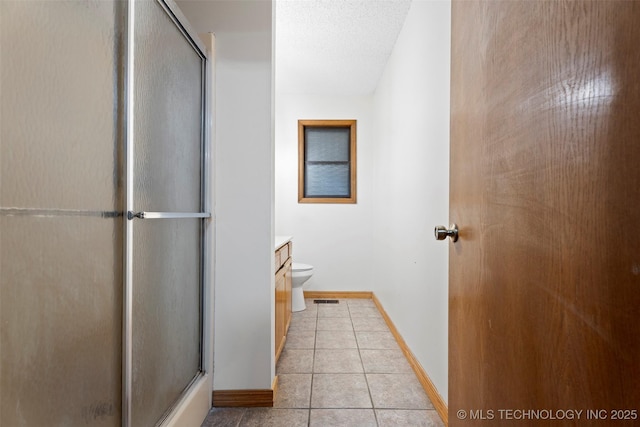 1558 E N Ridge Dr, Vinita, OK 74301 - full bathroom featuring a shower with shower door, tile patterned flooring, toilet, and baseboards