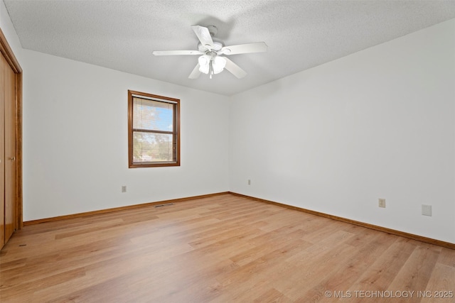 1558 E N Ridge Dr, Vinita, OK 74301 - unfurnished bedroom with light wood-type flooring, baseboards, a closet, a textured ceiling, and ceiling fan