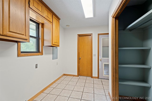 1558 E N Ridge Dr, Vinita, OK 74301 - kitchen featuring baseboards, light tile patterned floors, and brown cabinetry