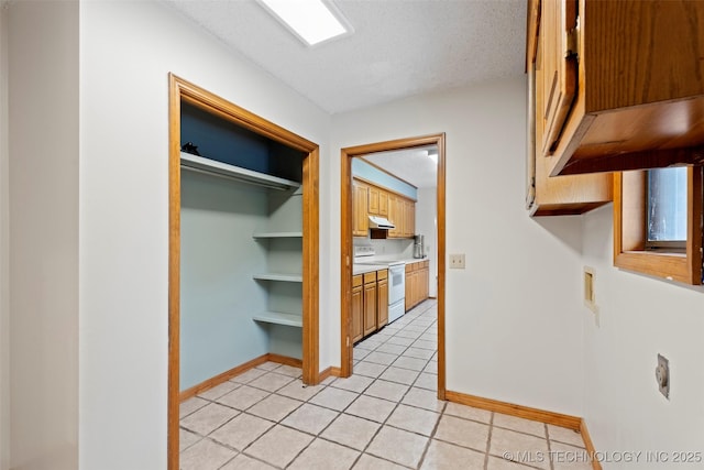 1558 E N Ridge Dr, Vinita, OK 74301 - corridor featuring light tile patterned flooring, baseboards, and a textured ceiling