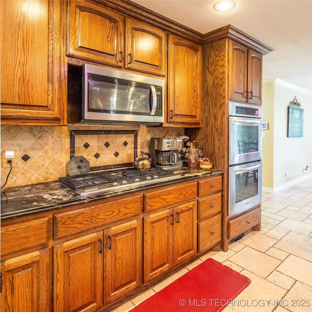 20 Quail, Mcalester, OK 74501 - kitchen with appliances with stainless steel finishes, dark stone counters, crown molding, tasteful backsplash, and brown cabinets