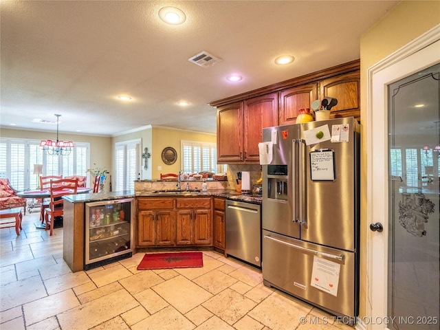 20 Quail, Mcalester, OK 74501 - kitchen featuring appliances with stainless steel finishes, beverage cooler, a sink, a peninsula, and a chandelier