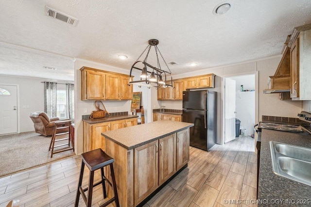 150 Private Road 121, Eucha, OK 74342 - kitchen with freestanding refrigerator, a center island, wood finish floors, a textured ceiling, and dark countertops