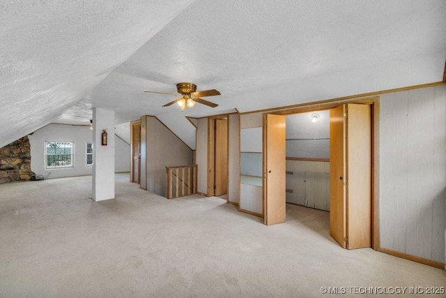 326 E 437th Rd, Spavinaw, OK 74366 - additional living space featuring a textured ceiling, lofted ceiling, carpet flooring, a ceiling fan, and wooden walls