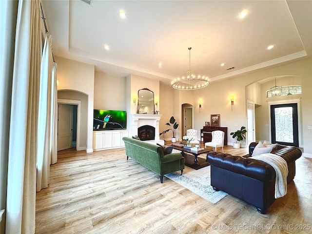 20115 W 111th St S, Sapulpa, OK 74066 - living area with arched walkways, light wood finished floors, recessed lighting, and a tray ceiling
