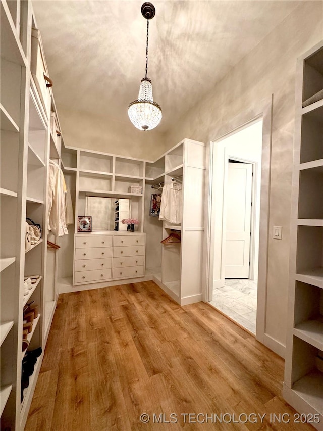 20115 W 111th St S, Sapulpa, OK 74066 - walk in closet featuring wood finished floors and a chandelier