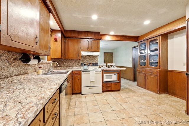 73645 Cyclone Cir, Wagoner, OK 74467 - kitchen with white appliances, a sink, under cabinet range hood, brown cabinetry, and light countertops