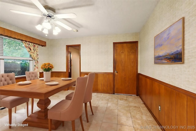 73645 Cyclone Cir, Wagoner, OK 74467 - dining area featuring a wainscoted wall, wood walls, a ceiling fan, wallpapered walls, and light tile patterned floors