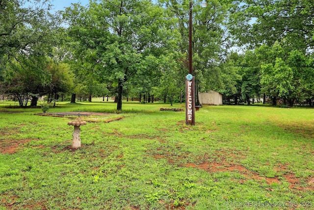 73645 Cyclone Cir, Wagoner, OK 74467 - view of green lawn featuring view of wooded area and an outdoor structure