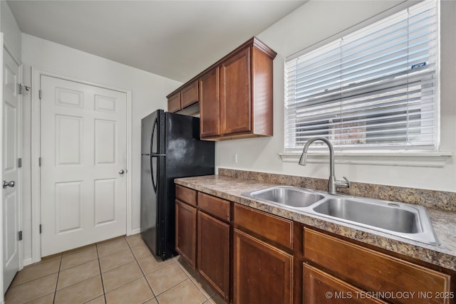 2713 N 20th St, Broken Arrow, OK 74012 - kitchen featuring a sink, freestanding refrigerator, light tile patterned flooring, and brown cabinets