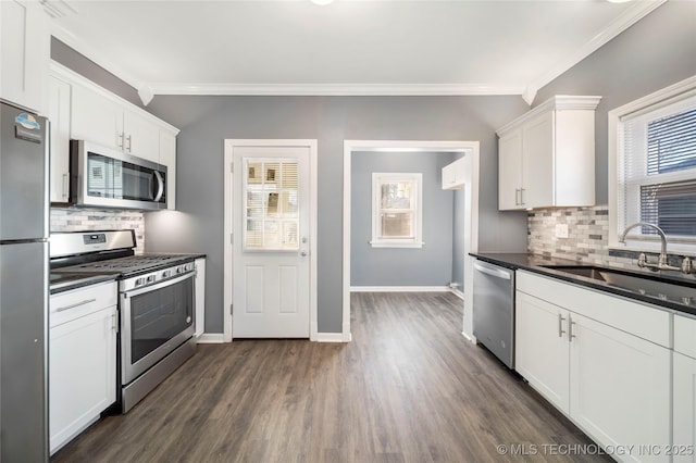 1232 S Gary Pl, Tulsa, OK 74104 - kitchen featuring appliances with stainless steel finishes, a sink, plenty of natural light, dark countertops, and crown molding