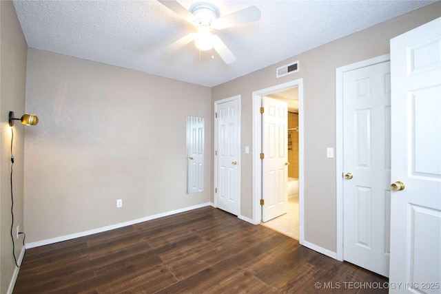 6737 S Peoria Ave Unit C213, Tulsa, OK 74136 - unfurnished bedroom with wood finished floors, baseboards, ceiling fan, a textured ceiling, and connected bathroom
