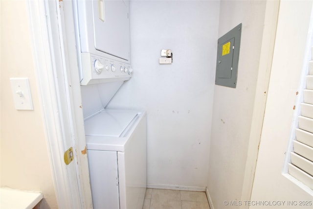 6737 S Peoria Ave Unit C213, Tulsa, OK 74136 - washroom featuring stacked washing machine and dryer, electric panel, light tile patterned flooring, and baseboards