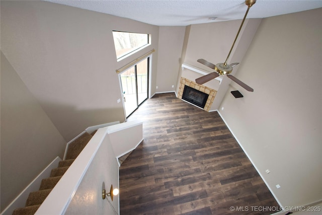 6737 S Peoria Ave Unit C213, Tulsa, OK 74136 - unfurnished living room featuring wood finished floors, a fireplace, ceiling fan, a textured ceiling, and baseboards