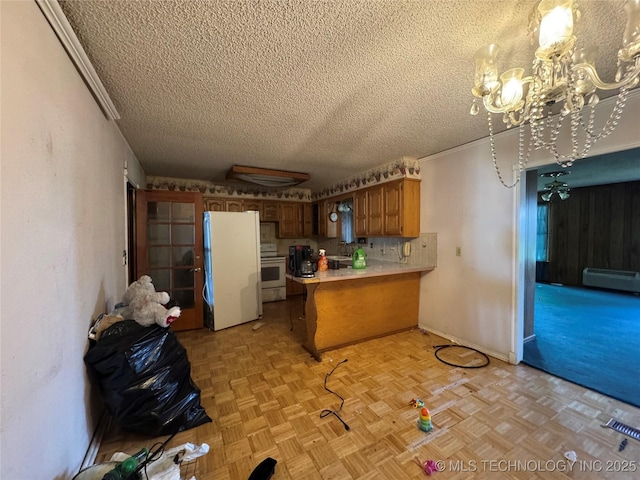 10653 E 18th St, Tulsa, OK 74128 - kitchen with white appliances, a textured ceiling, a peninsula, a baseboard radiator, and light countertops