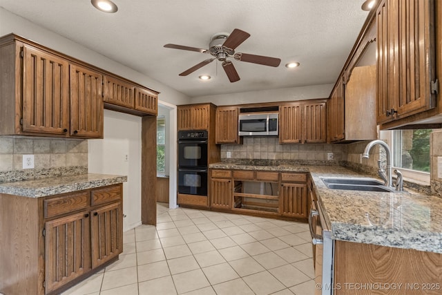 8424 Harp Blvd, Broken Arrow, OK 74014 - kitchen with a sink, black appliances, a ceiling fan, brown cabinetry, and backsplash