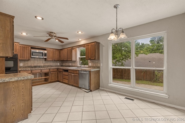 8424 Harp Blvd, Broken Arrow, OK 74014 - kitchen featuring stainless steel appliances, brown cabinetry, decorative backsplash, recessed lighting, and a textured ceiling