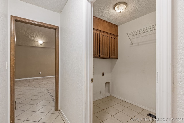 8424 Harp Blvd, Broken Arrow, OK 74014 - laundry room with cabinet space, light tile patterned floors, a textured ceiling, hookup for an electric dryer, and baseboards