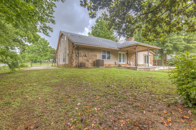 8424 Harp Blvd, Broken Arrow, OK 74014 - rear view of house featuring stone siding, a patio, central AC unit, and a chimney