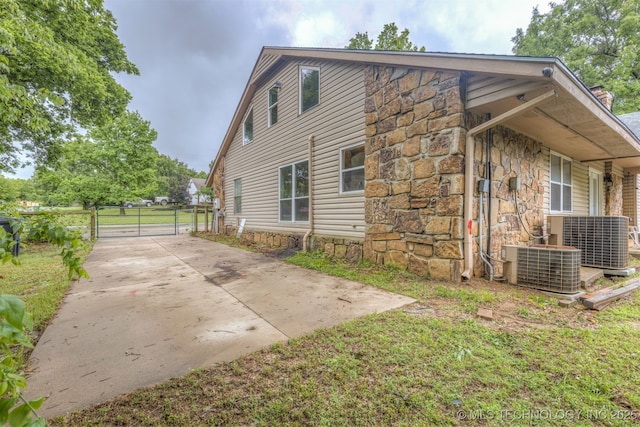 8424 Harp Blvd, Broken Arrow, OK 74014 - view of side of home with a gate, central AC unit, and stone siding
