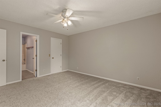 4012 S Cedar Ave, Broken Arrow, OK 74011 - unfurnished bedroom with carpet, baseboards, a textured ceiling, connected bathroom, and ceiling fan