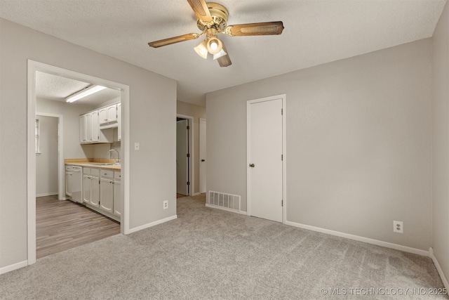 4012 S Cedar Ave, Broken Arrow, OK 74011 - unfurnished room featuring light carpet, ceiling fan, baseboards, and a sink
