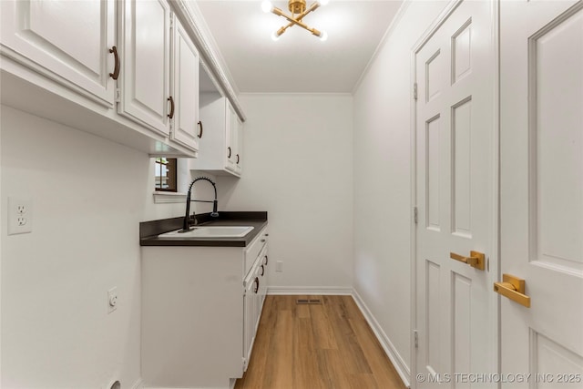 7802 S Joplin Ave, Tulsa, OK 74136 - laundry area featuring light wood-style flooring, cabinet space, and baseboards