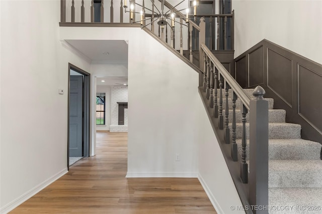 7802 S Joplin Ave, Tulsa, OK 74136 - stairs featuring wood finished floors, baseboards, crown molding, and a chandelier