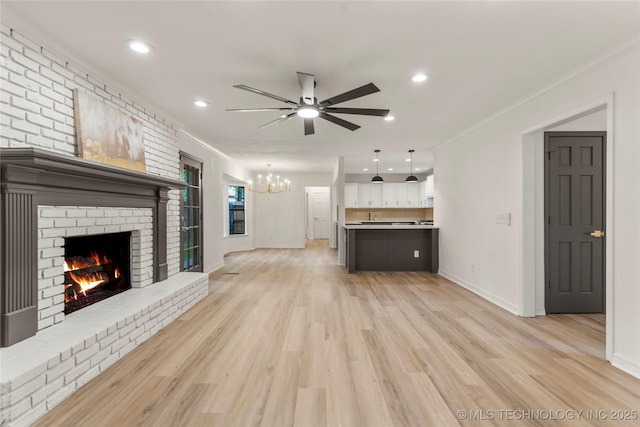 7802 S Joplin Ave, Tulsa, OK 74136 - unfurnished living room with a fireplace, a chandelier, ornamental molding, ceiling fan, and light wood-style floors