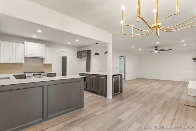 7802 S Joplin Ave, Tulsa, OK 74136 - kitchen featuring wine cooler, stainless steel gas stove, recessed lighting, decorative backsplash, and white cabinets