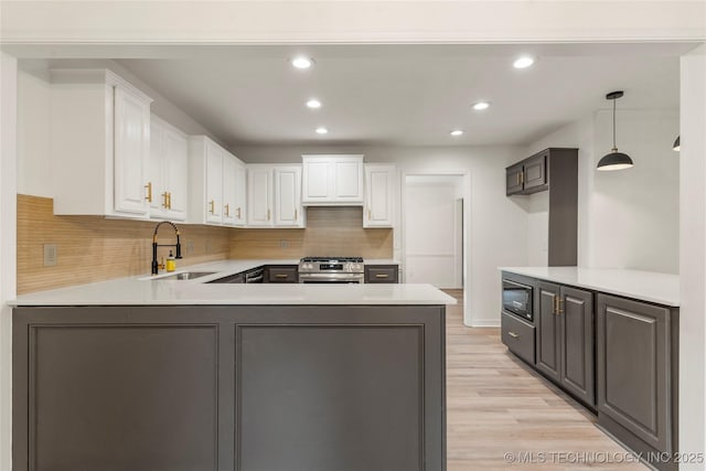 7802 S Joplin Ave, Tulsa, OK 74136 - kitchen with a sink, stainless steel gas stove, a peninsula, recessed lighting, and decorative backsplash