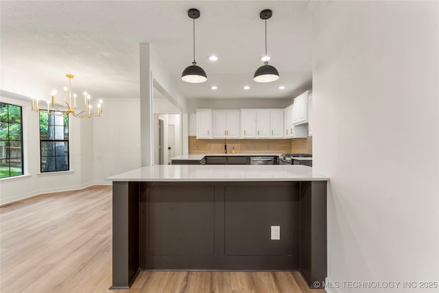 7802 S Joplin Ave, Tulsa, OK 74136 - kitchen with a sink, stainless steel appliances, white cabinets, backsplash, and a chandelier