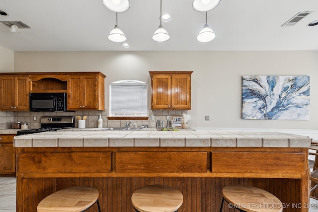 12326 S Cedar Ave, Jenks, OK 74037 - kitchen featuring black microwave, stainless steel range with gas stovetop, a sink, tasteful backsplash, and light countertops