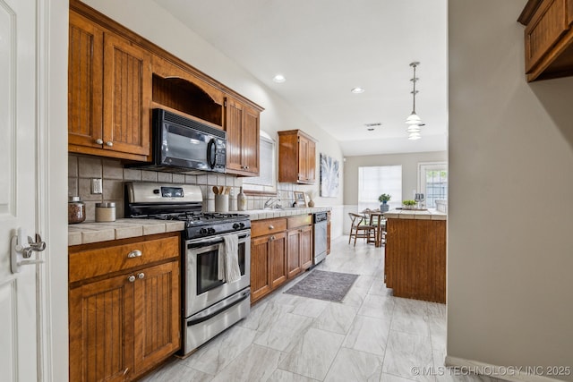 12326 S Cedar Ave, Jenks, OK 74037 - kitchen featuring stainless steel appliances, tile countertops, backsplash, brown cabinetry, and recessed lighting
