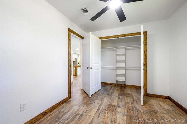 984 Ridgepoint, Fort Towson, OK 74735 - unfurnished bedroom with baseboards, wood finished floors, a closet, and ceiling fan