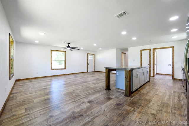 984 Ridgepoint, Fort Towson, OK 74735 - kitchen featuring wood finished floors, a breakfast bar area, ceiling fan, and recessed lighting