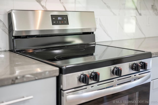 984 Ridgepoint, Fort Towson, OK 74735 - detailed view of stainless steel electric range, light countertops, and backsplash