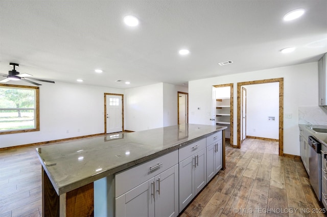 984 Ridgepoint, Fort Towson, OK 74735 - kitchen featuring wood finished floors, stainless steel dishwasher, ceiling fan, dark stone countertops, and recessed lighting